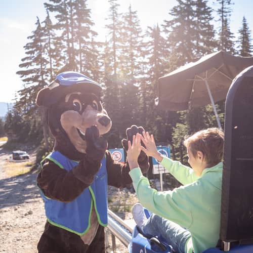 gnarly bear high fiving a child at the eagle coaster 