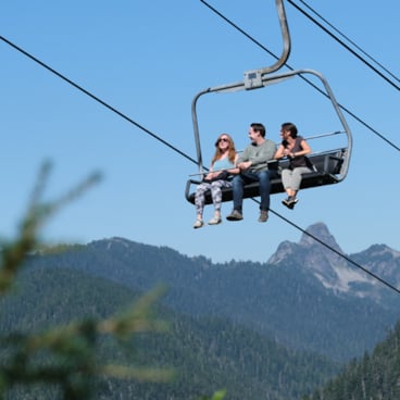 three friends on a chairlift in the summer