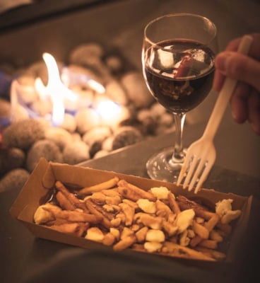 poutine and wine around a fire 